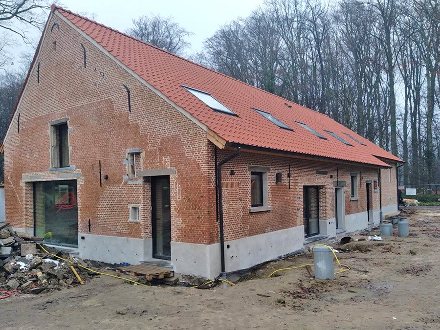 Hoeve met nieuw rood pannendak en bakstenen gevel
