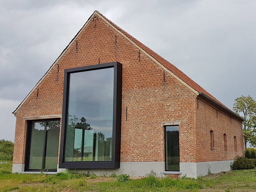 Hoeve met bakstenen gevel en groot glazen vlak