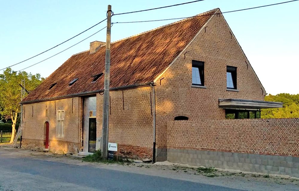Oude hoeve met bakstenen gevel langs de straat